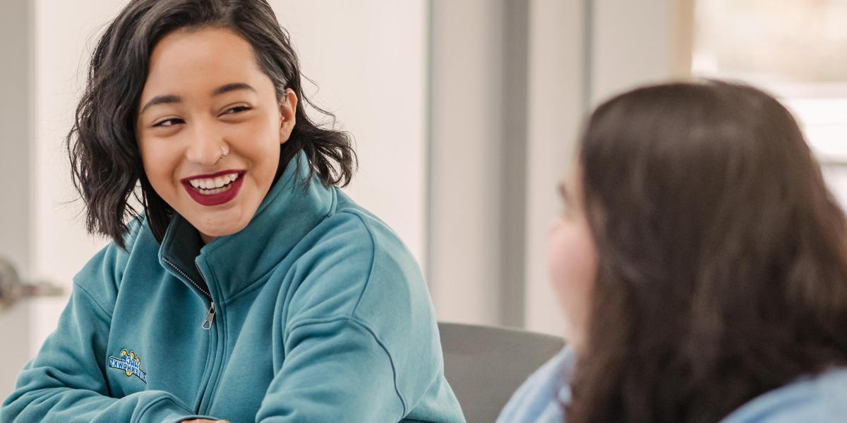 Student smiling and looking at other student.